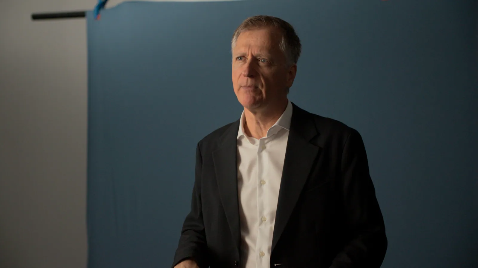 Dr. Stephen Yuille in a studio, against a blue backdrop.